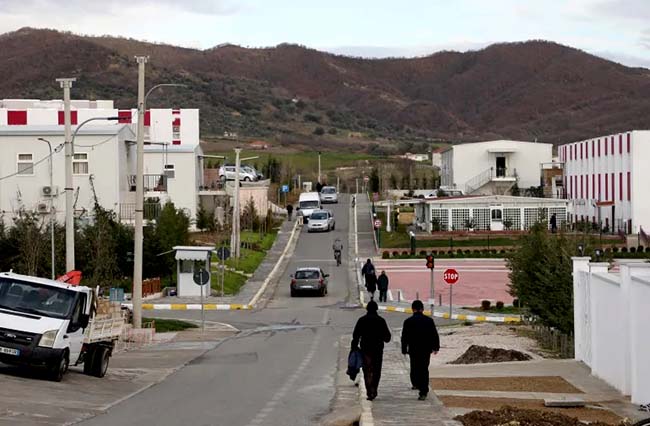 A street at Ashraf-3 camp with hills in the backgroundMEK members walk in a street at the Ashraf-3 camp on March 4, 2020 [Gent Shkullaku/AFP]