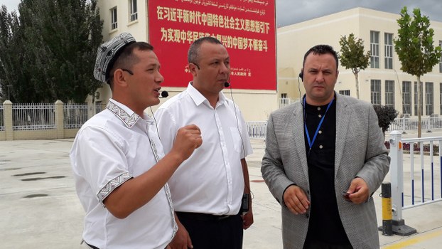Olsi Jazexhi (R) listens to a handler during a tour of a mosque in Aksu city, in China’s Xinjiang Uyghur Autonomous Region (XUAR), Aug. 21, 2019